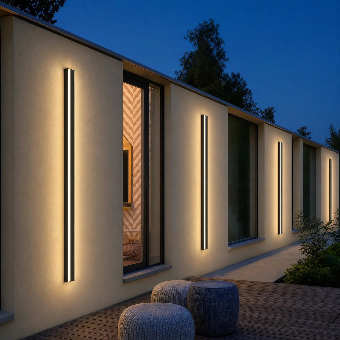 Several Dovlin outdoor LED wall lights lining a façade at dusk | Wickleigh
