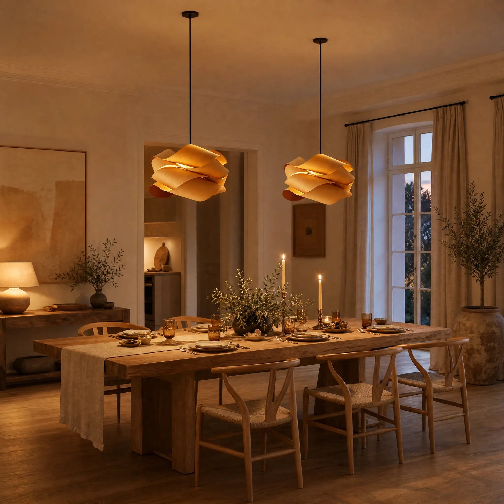 Two Vinin wood pendant lights lit above a large, laid dining table | Wickleigh