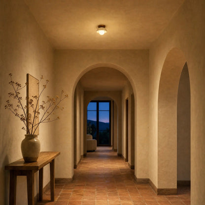 Melna travertine ceiling light lit in a vaulted hallway at dusk | Wickleigh