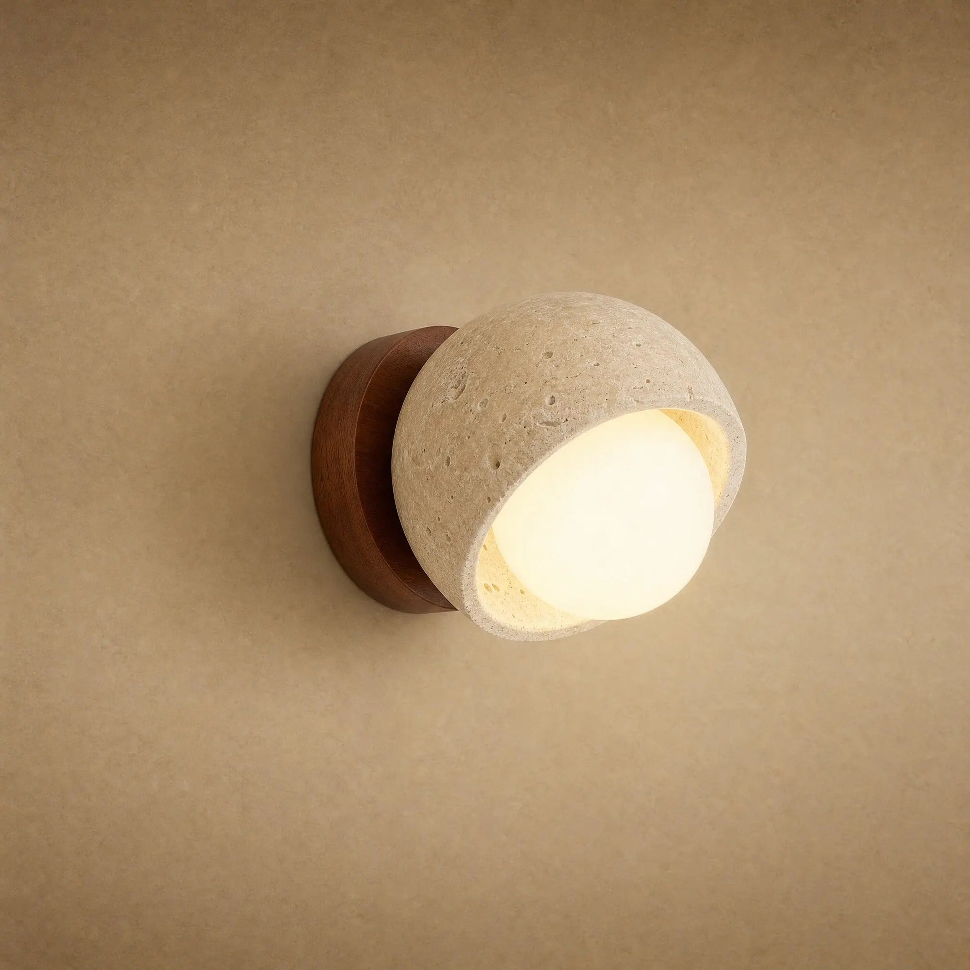 Melna wall light in yellow travertine and walnut, opal globe lit | Wickleigh