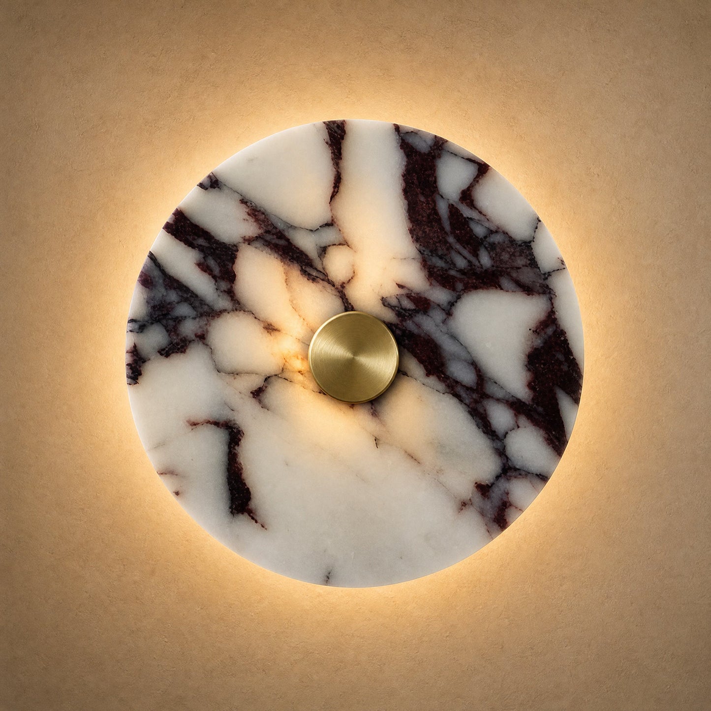 Belna Art Deco wall light, plum veined stone disc with gold metal hub, lit | Wickleigh