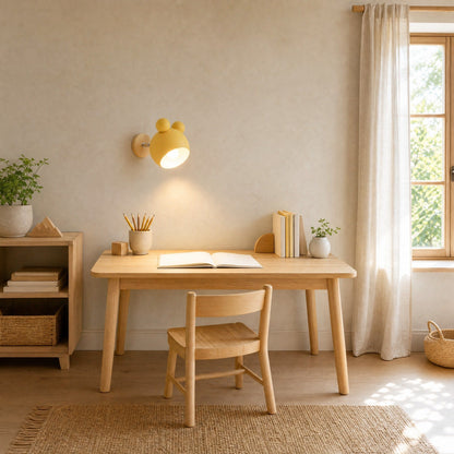 Berrin yellow wall light tilted towards a light oak child's desk | Wickleigh