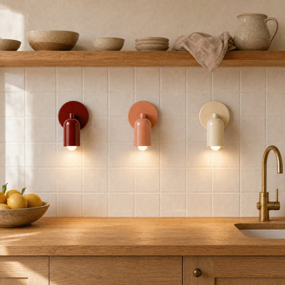 Three Cadren wall lights, cream, terracotta and brick red, lined up above a worktop | Wickleigh