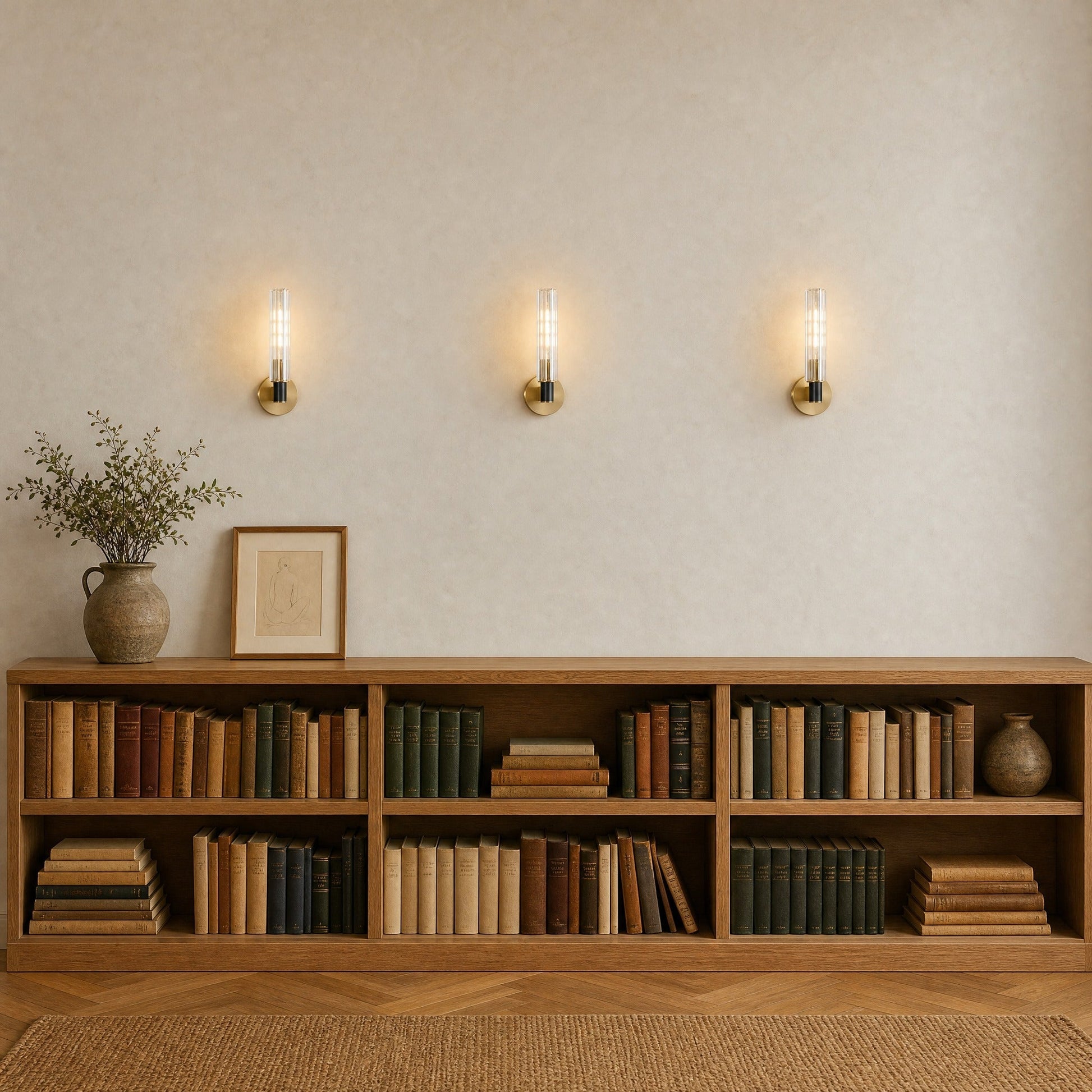 Three Calin wall lights lit in a row above an oak shelf, library hallway | Wickleigh