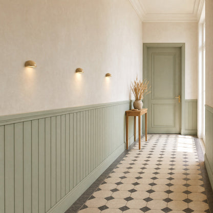 Three Calvra wall lights lined up in a hallway with sea-green panelling | Wickleigh