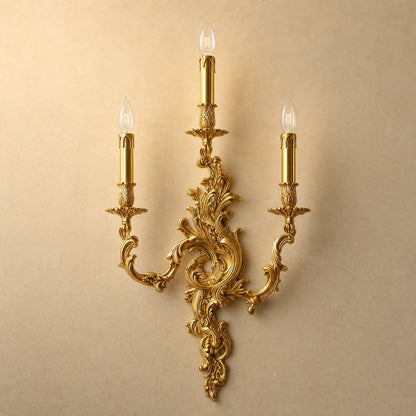 Cerna gold candle wall light, three-candle rococo design, packshot on sand background | Wickleigh