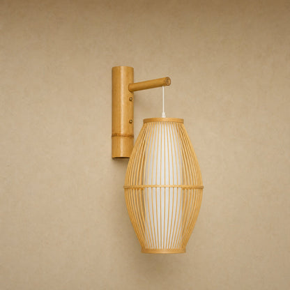 Halna natural wall light, woven bamboo cocoon on a wall arm, front view | Wickleigh