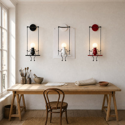 Three Jyllen wall lights, black, white and red, aligned above a workshop table | Wickleigh