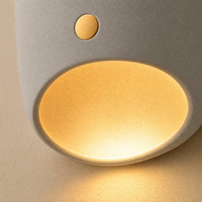 Detail of the matte resin and the lit ochre cavity of the Faelin wall light | Wickleigh