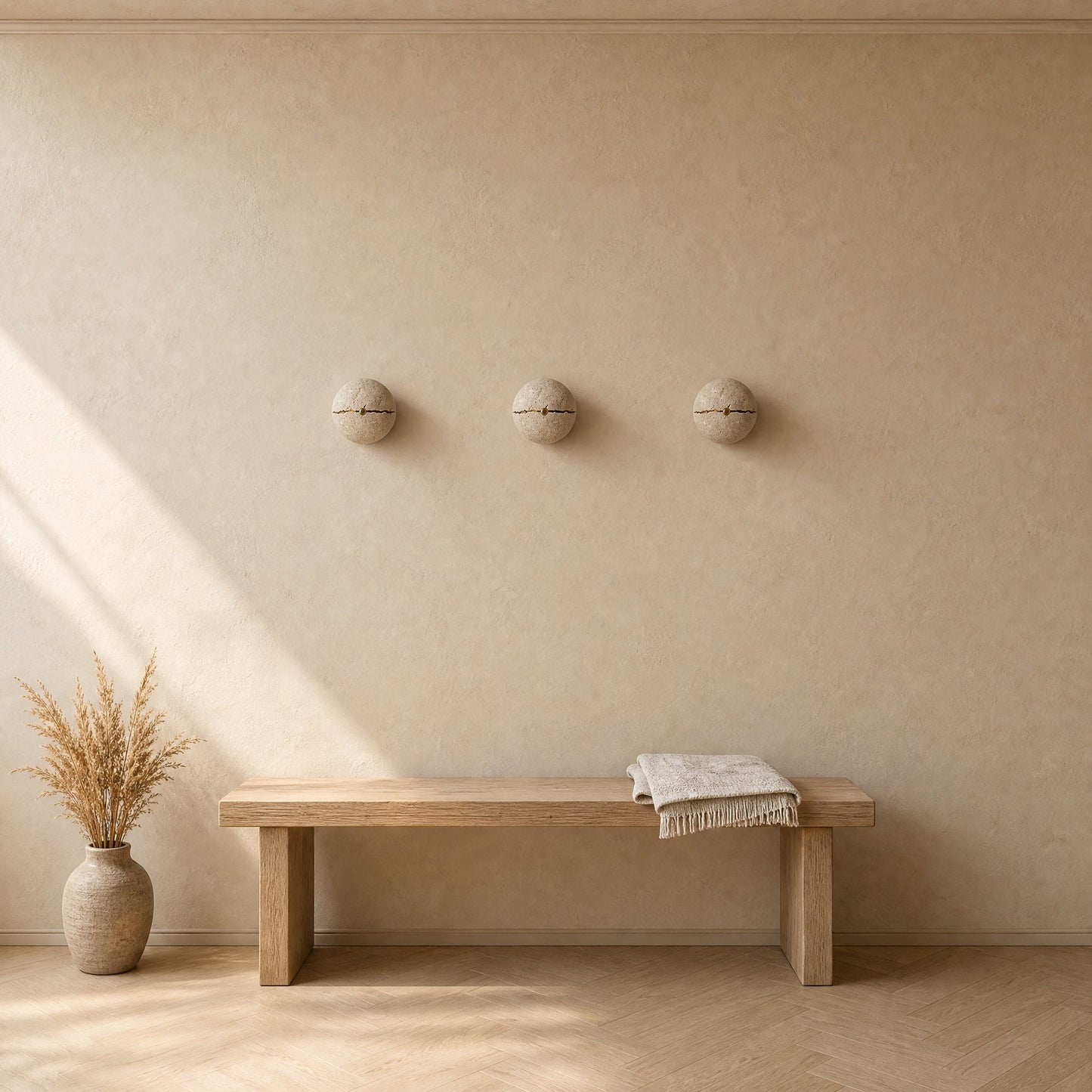 Three Rinen stone wall lights aligned above an oak bench in an entrance, natural light | Wickleigh