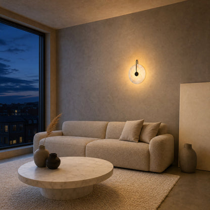 Henin marble wall light lit above a sand boucle sofa, on a polished concrete wall | Wickleigh