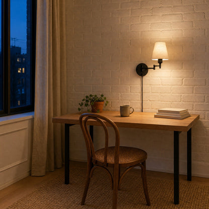 Runen fabric wall reading light lit above an oak desk, painted brick wall | Wickleigh