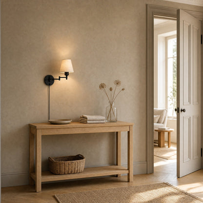 Runen fabric wall reading light lit above an oak console table in an entrance | Wickleigh