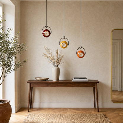 Trio of Broin pendant lights in red, yellow and orange cascading above a walnut hallway console | Wickleigh