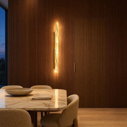 Frena crystal wall light lit against a fluted walnut wall in a villa dining room | Wickleigh