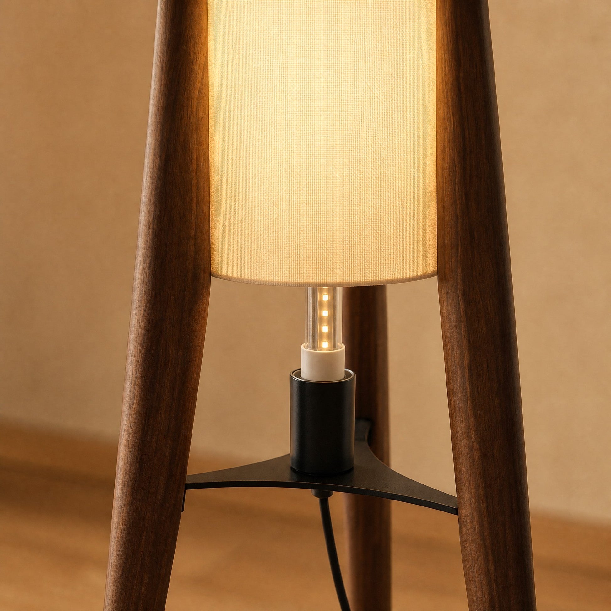 Detail of the wooden legs, black hub and E27 fitting on the Teira floor lamp | Wickleigh