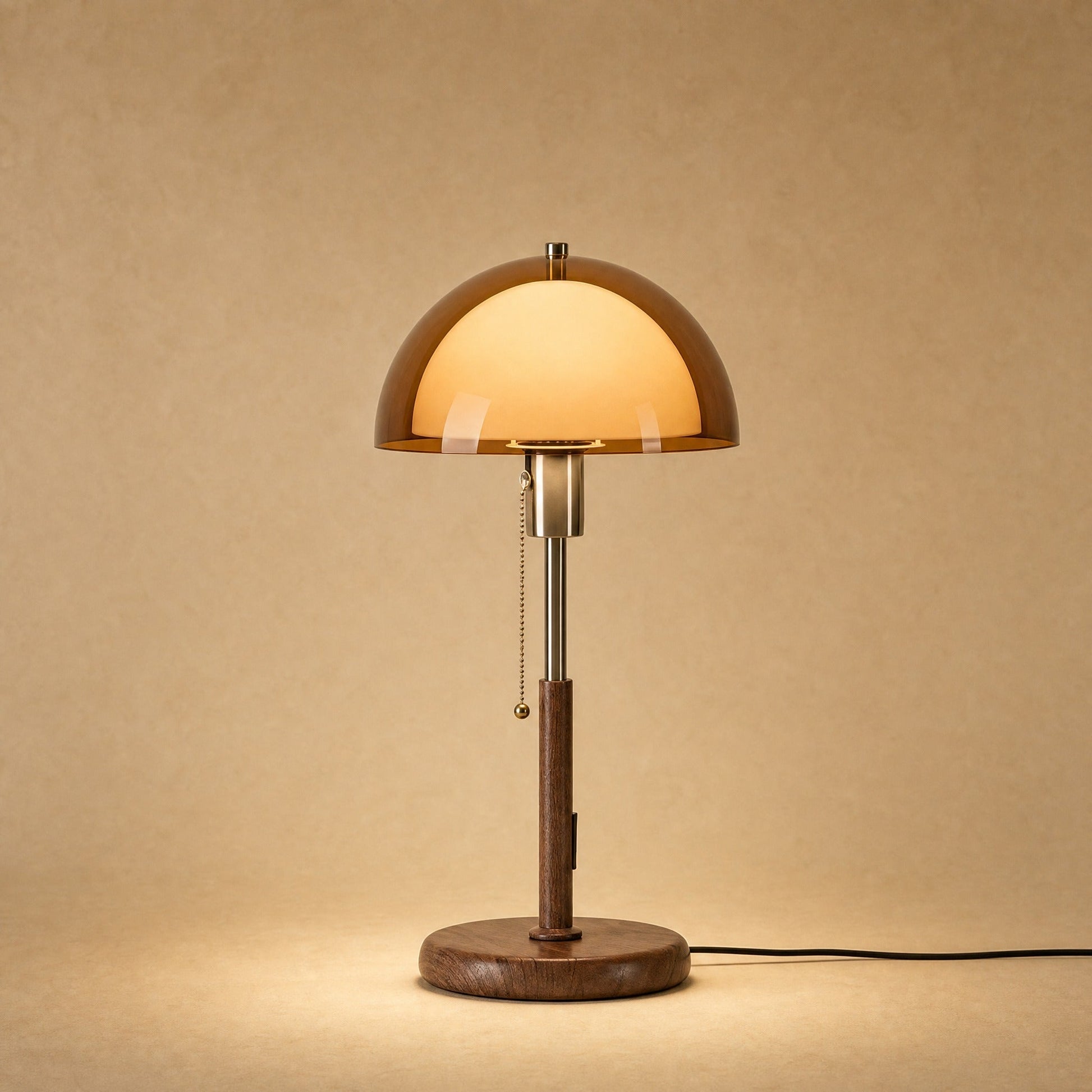 Sorlin amber dome table lamp lit, walnut-finish iron stand | Wickleigh