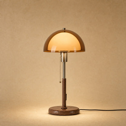 Sorlin amber dome table lamp lit, walnut-finish iron stand | Wickleigh