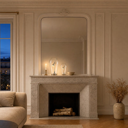 A pair of Alrin chrome lamps lit on a marble fireplace mantel | Wickleigh