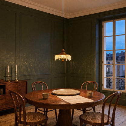 Elmin mini pendant light lit above a round walnut table, green panelled dining room | Wickleigh