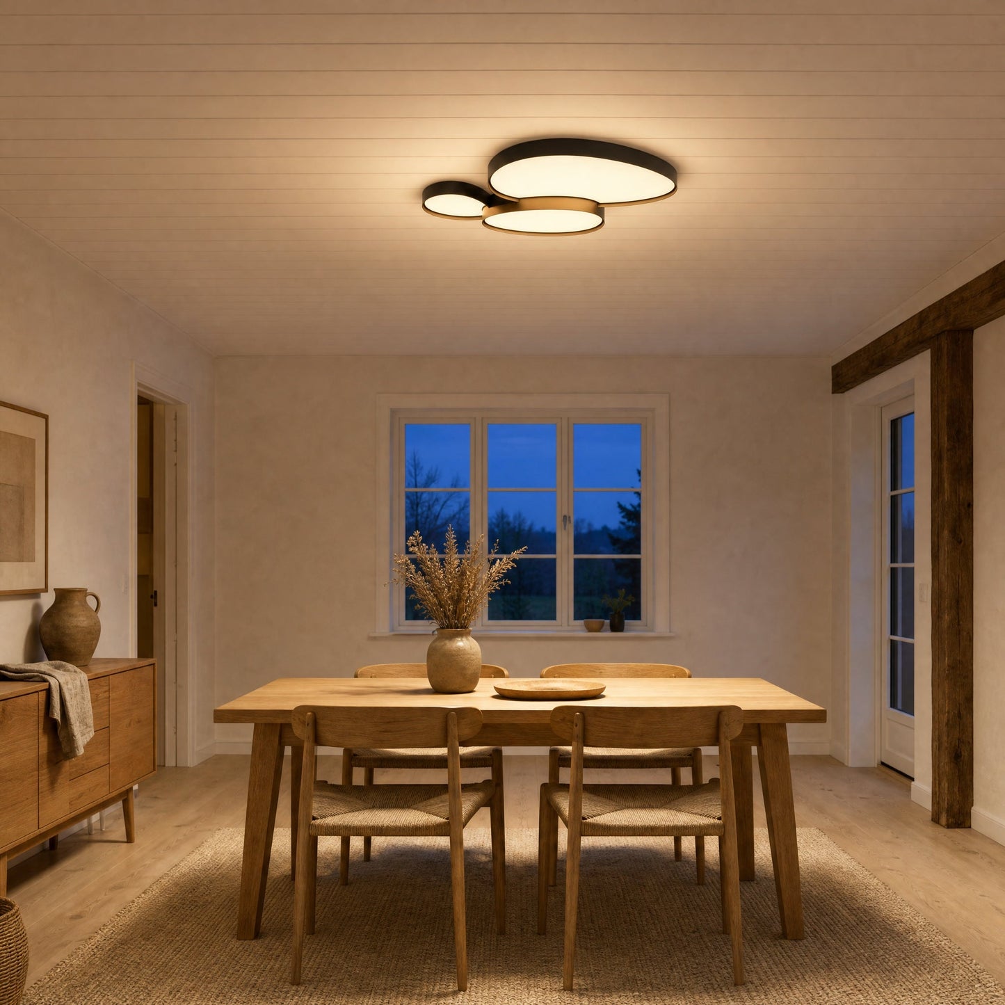 Teina black flush ceiling light lit above a Scandinavian dining table | Wickleigh