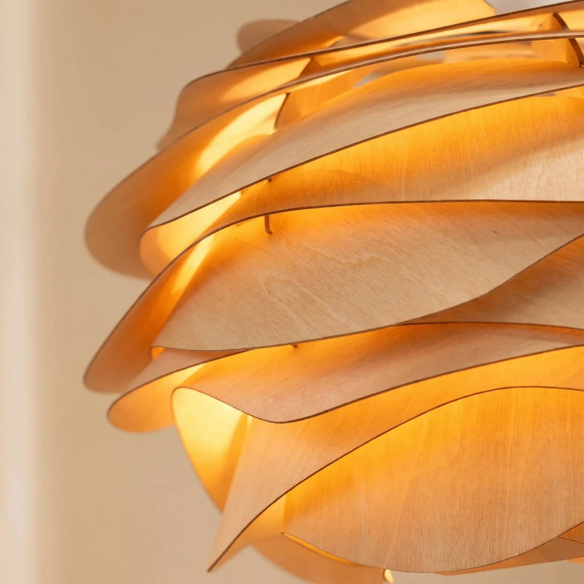 Detail of the Henlin sculpted wood pendant light's wooden petals, lit | Wickleigh