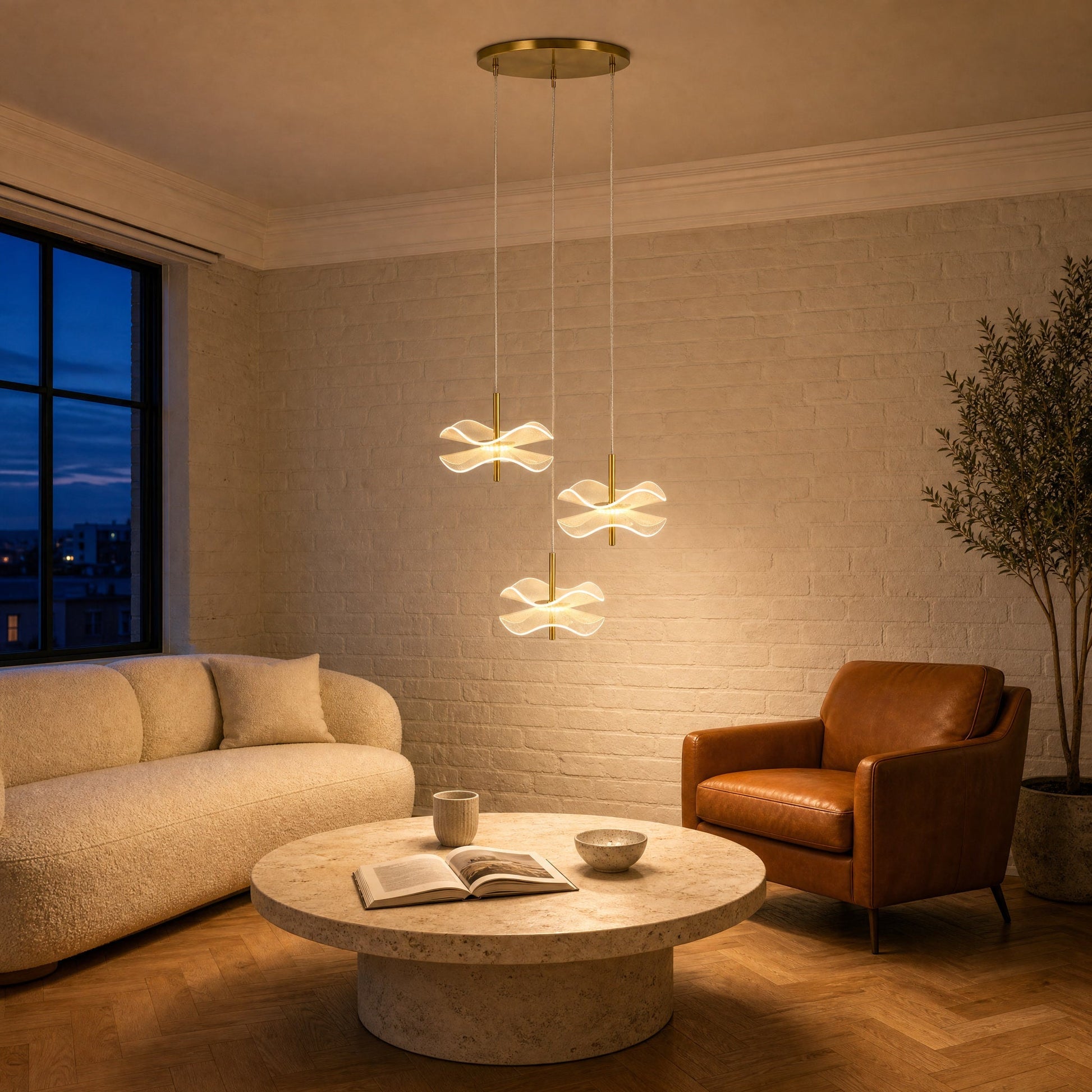 Three Orina flower pendant lights lit above a travertine coffee table in a white brick sitting room | Wickleigh