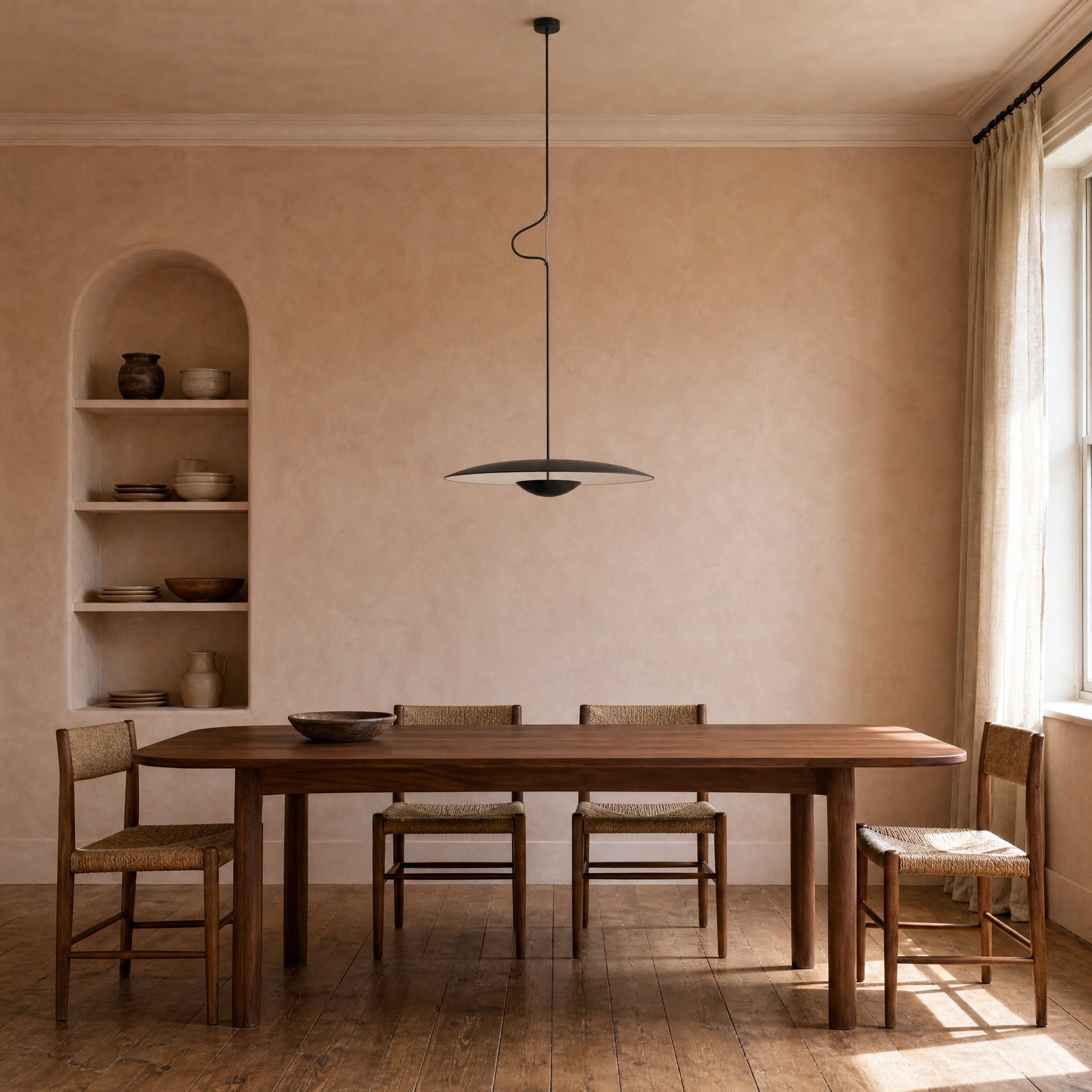 Fenna black pendant light above a walnut table in an ochre-walled dining room | Wickleigh