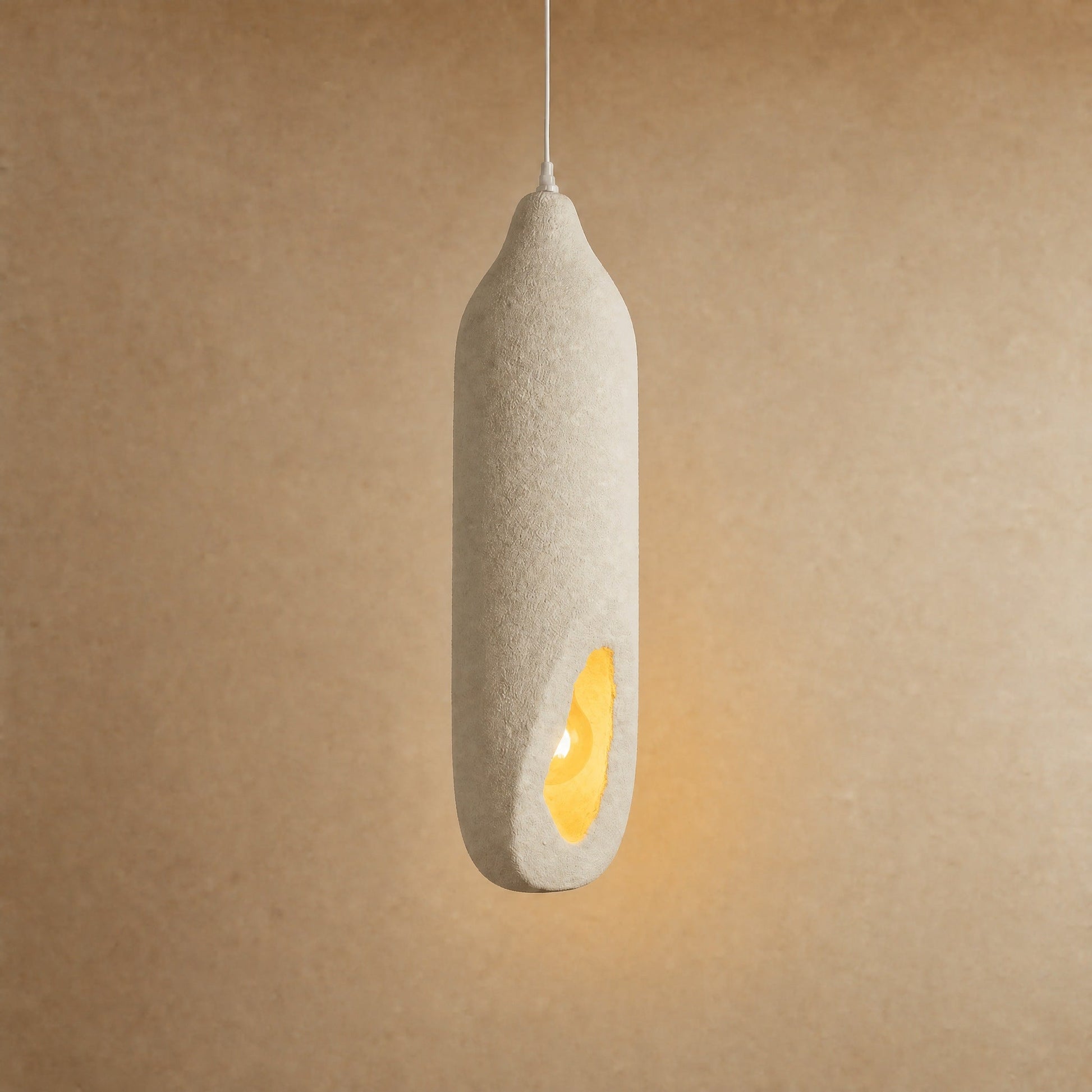 Korven pendant light switched on, an amber ember glowing within the ivory column | Wickleigh