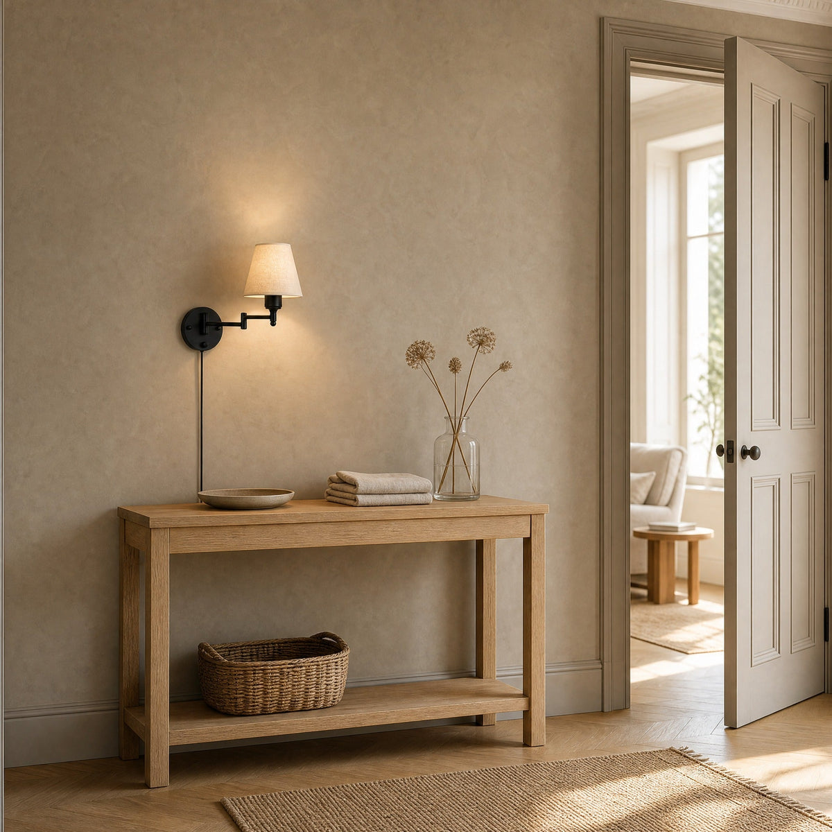 Runen fabric wall reading light lit above an oak console table in an entrance | Wickleigh